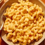 Crock pot mac and cheese in a bowl with a fork.