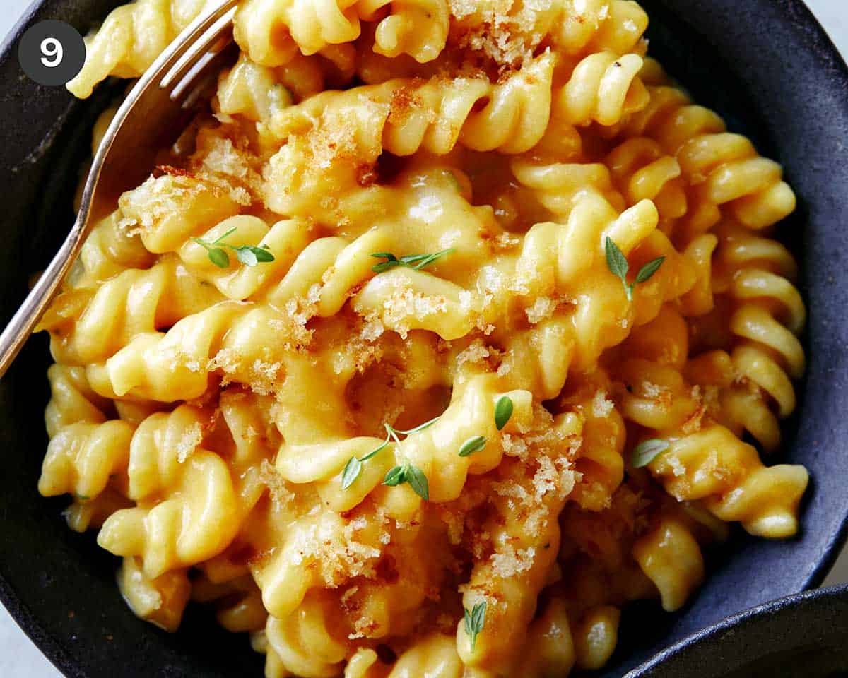 Pumpkin mac and cheese in a bowl with a fork in it.