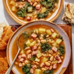 White bean and kale soup recipe in two bowls with bread on the side.