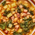 One bowl of white bean and kale soup up close.