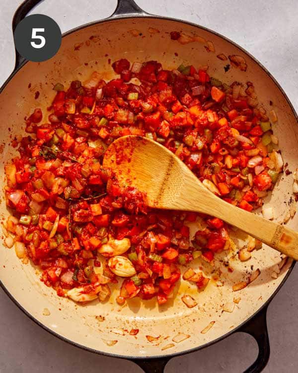 Veggies and tomato paste cooking in a skillet.