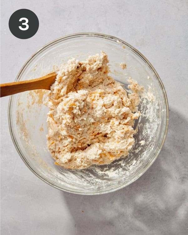 Wet ingredients added to a glass bowl to make biscuit dough.