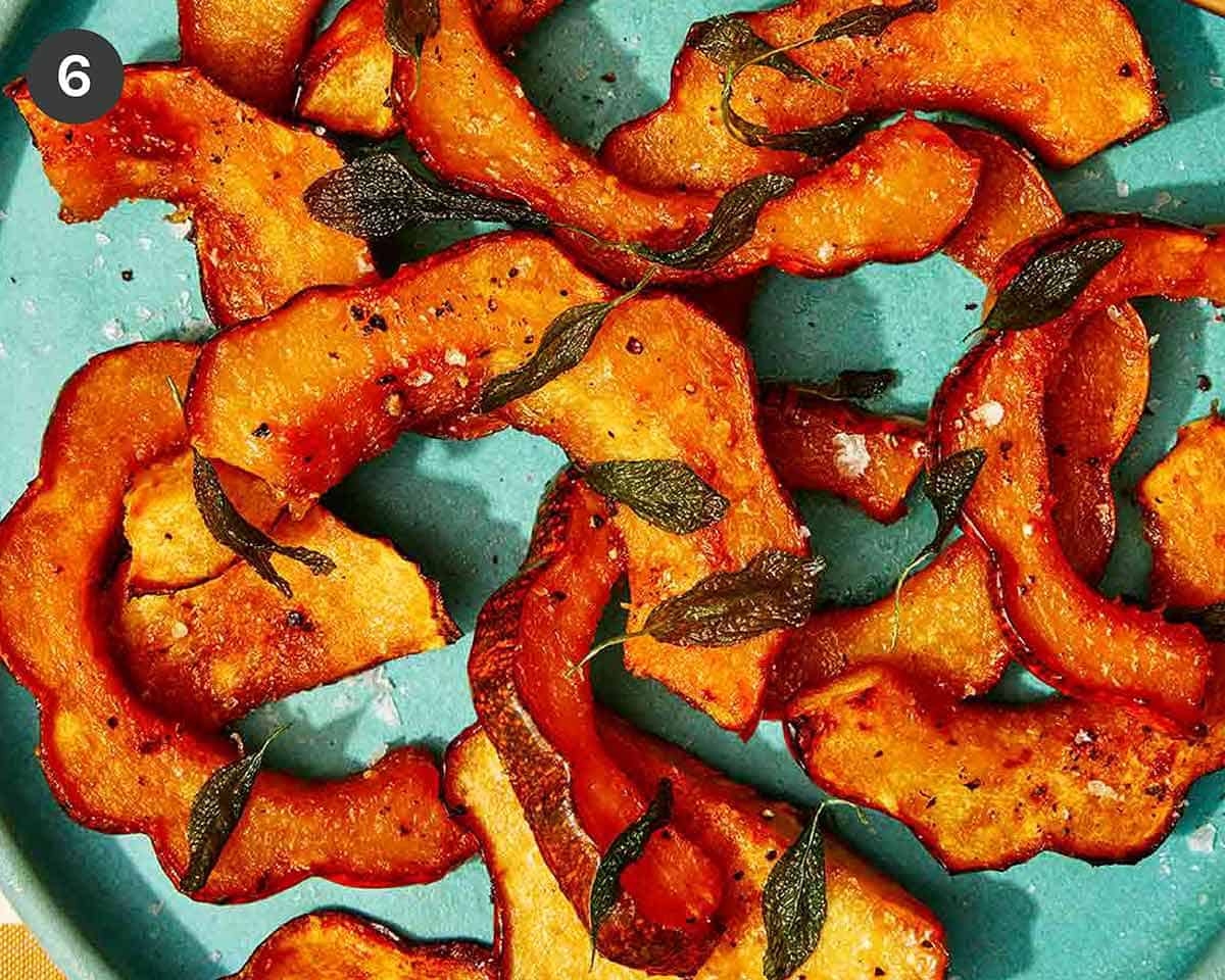 Roasted acorn squash topped with sage and salt ready to be served. 