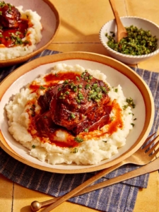 Braised short ribs on top of mashed potatoes in a bowl.