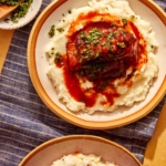 Braised short ribs in bowls with mashed potatoes.