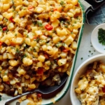 Close up on a baking dish filled with breakfast casserole with a bowl on the side.