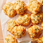 Up close on cheddar bay biscuits with one tore open.