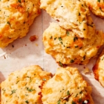 Up close on cheddar bay biscuits with one tore open.