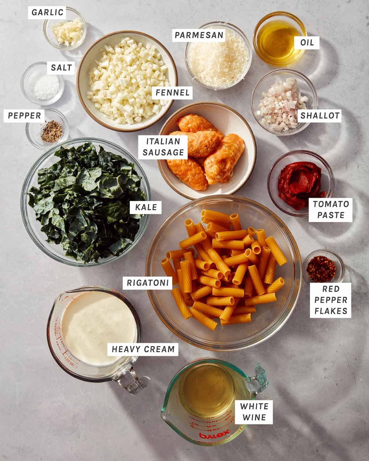 Ingredients to make a kale and sausage rigatoni recipe all laid out.