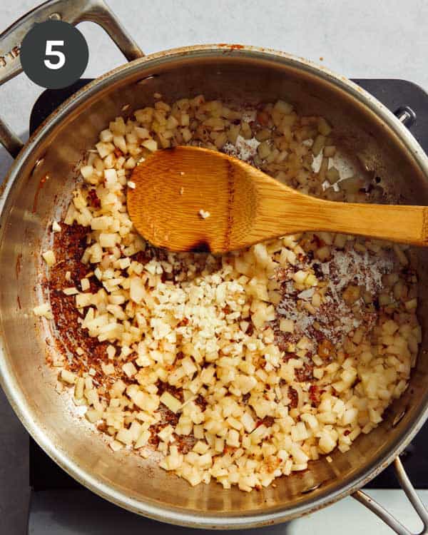 A skillet that has fennel and garlic in it cooking to make a pasta recipe.