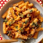 Close up on a bowl of kale and sausage rigatoni in a bowl with a fork.