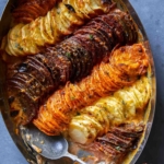 A close up of cheesy root vegetable gratin with a spoon.