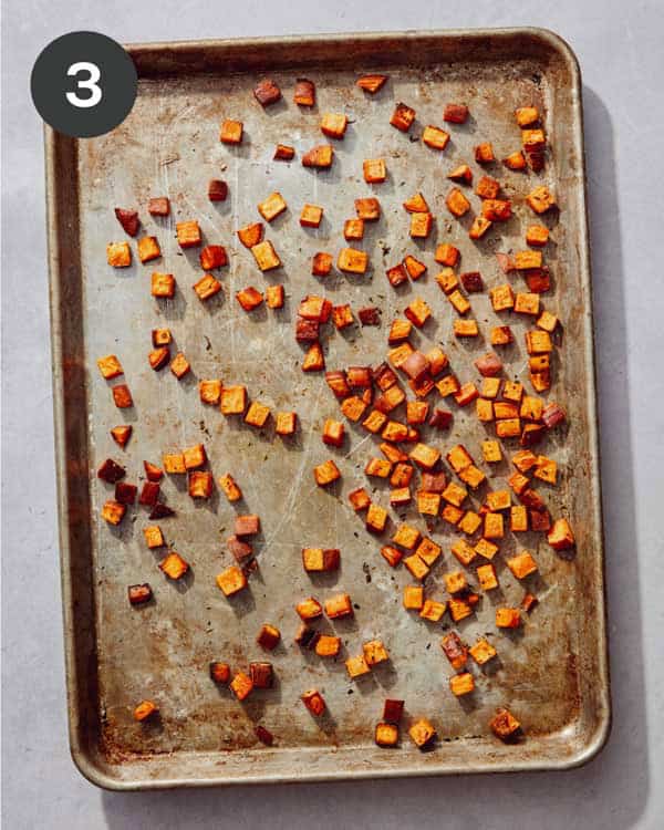 Freshly roasted sweet potatoes on a baking sheet.