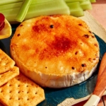 Honey Brûlée Brie being served in a platter with crackers and veggies.