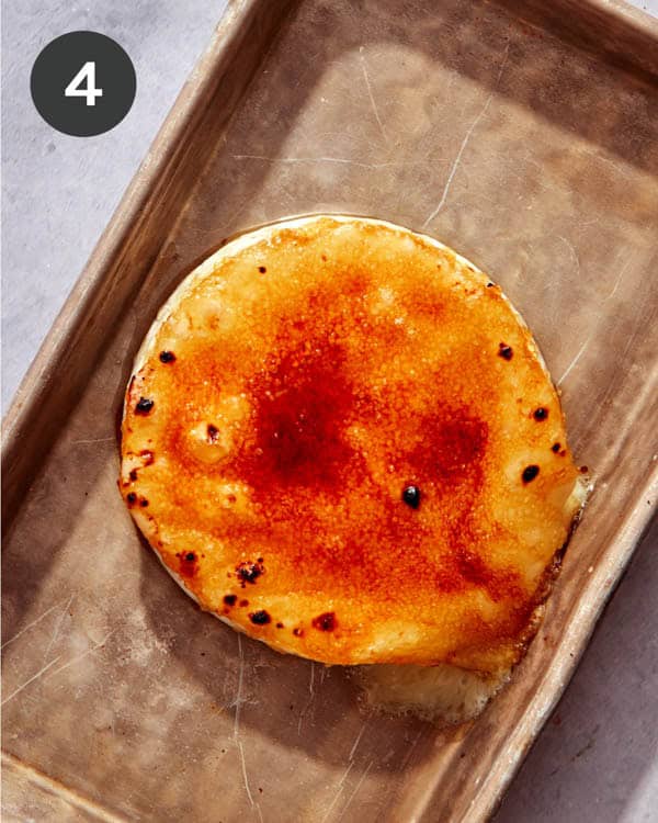 Honey Brûlée Brie freshly broiled on a baking sheet.