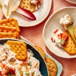 Million dollar dip being served onto little appetizer plates.