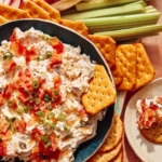 Million dollar dip with a cracker being dipping into it.