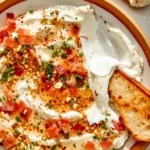 Whipped goat cheese with a crostini dipped in it.