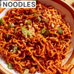 Spicy ramen noodles being eaten with chopsticks.