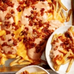 Animal style fries on a baking sheet.