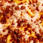 Animal style fries on a baking sheet up close.