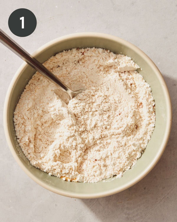 A flour mixture in a bowl with a fork to make mozzarella sticks.