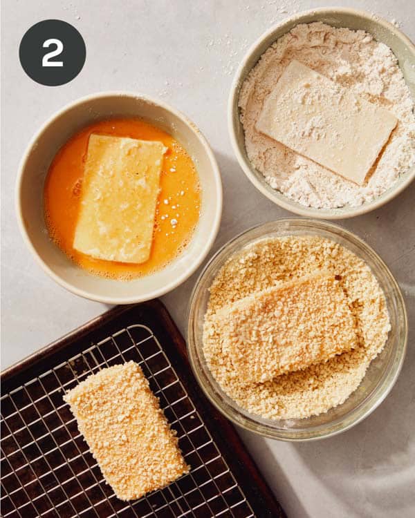 Mozzarella sticks being dredged to be ready to be fried.