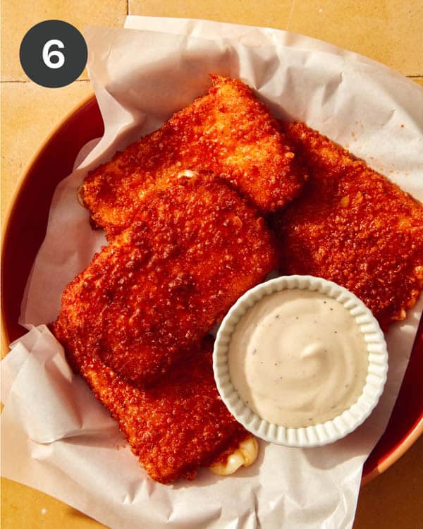 Mozzarella sticks in a basket with ranch on the side.