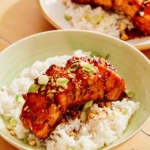 Soy glazed salmon on a bed of rice with a fork.