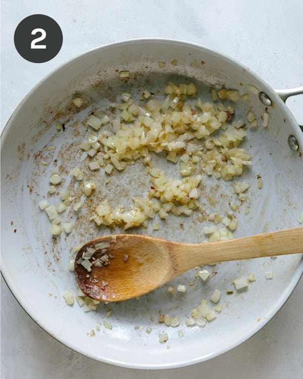Onions and garlic cooking in a skillet. 