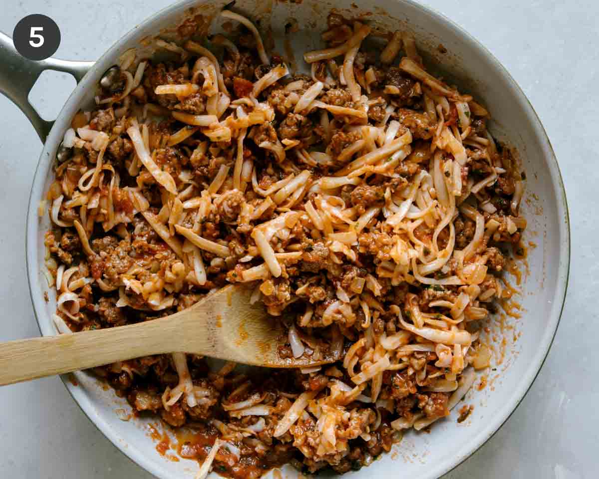 Zucchini boat filling a skillet with cheese. 