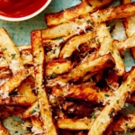 Air fryer french fries on a platter with ketchup and mayo.