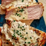 Air fryer pork chops on a platter up close with a sauce over top.
