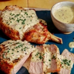 Air fryer pork chops on a platter with a cream sauce.