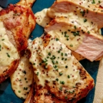 Air fryer pork chops on a platter up close with a sauce over top.