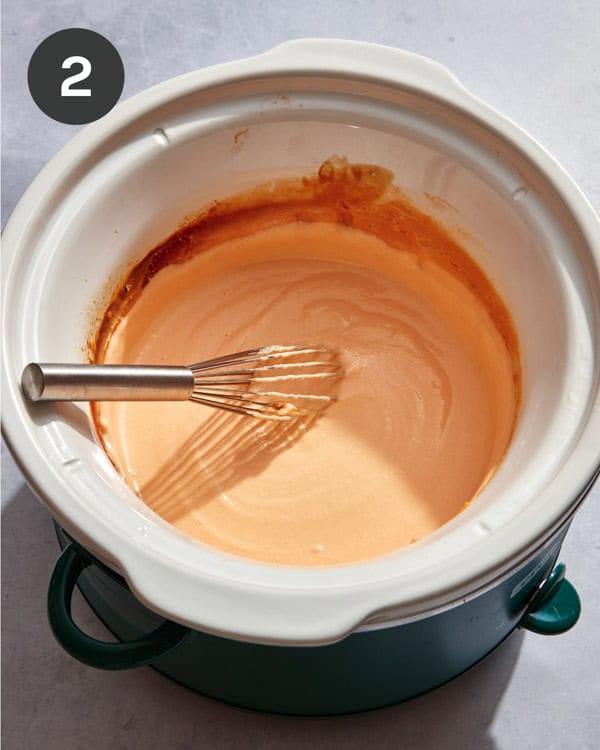 Beer cheese dip being whisked together in a bowl.