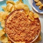 Fried pickle dip in a bowl with potato chips.