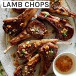A platter of garlic butter lamb chops with a container on garlic butter next to them.