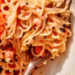 Close up on a fork wound with creamy smoked salmon pasta.
