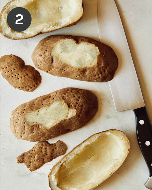 Leveling out potato halves by cutting the bottom off.