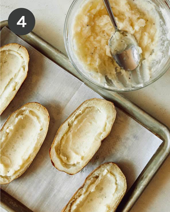 Mashed potatoes spread into the bottom of potato halves.