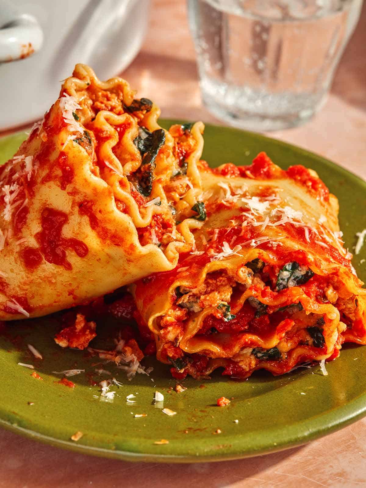Close up on a plate of two lasagna roll ups.