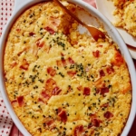 Corn casserole recipe prepared with a scoop taken out.