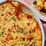 Corn casserole recipe with some scooped out on a plate.
