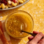 Italian vinaigrette dressing in a jar being mixed with a spoon.