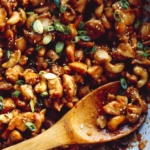 Cashew chicken recipe in a skillet with rice on the side.