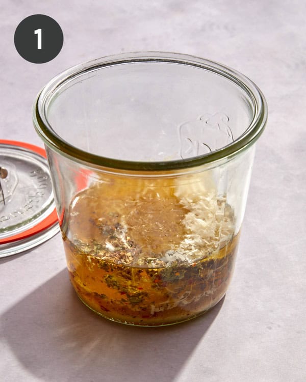 Ingredients for an Italian vinaigrette poured into a jar.