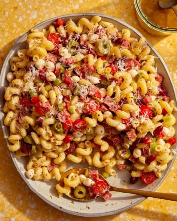 Pasta salad in a big bowl with a spoon in it.