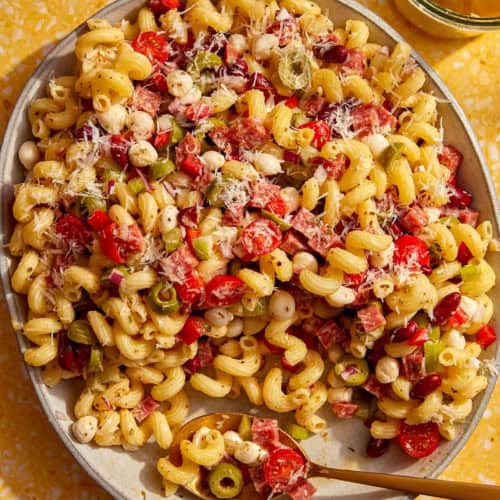 Pasta salad in a big bowl with a spoon in it.