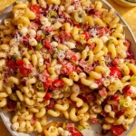 Pasta salad in a big bowl with a spoon in it.